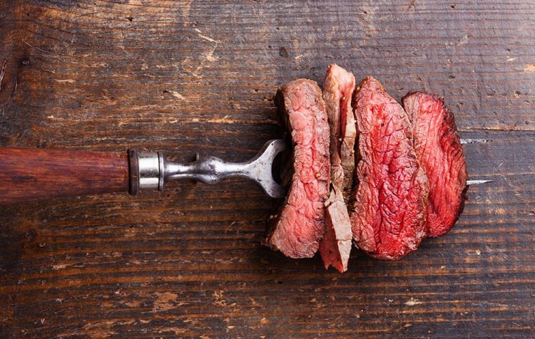 Houten snijplank en vork met vlees